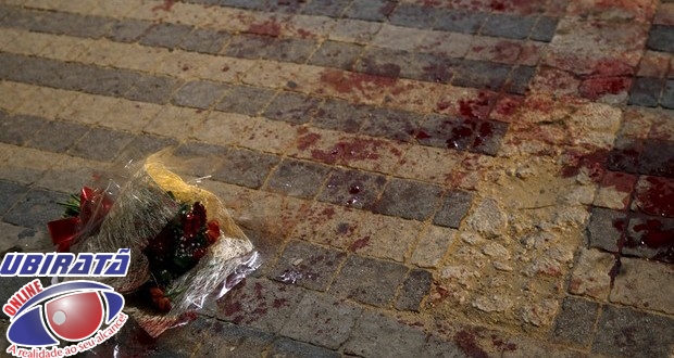 Buquê de flores em poça de sangue onde várias pessoas foram esfaqueadas na área portuária de Jaffa, em Tel Aviv (Foto: Amir Cohen/Reuters)