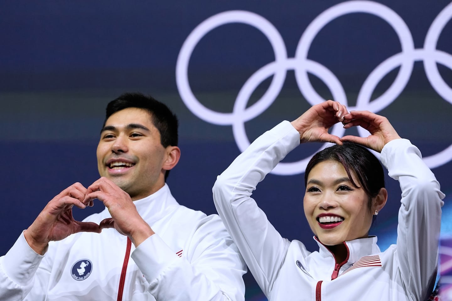 Emily Chan (right) and Spencer Akira Howe of the United States react to their scores after pairs short program Sunday.