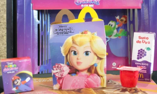 Caixa de McLanche Feliz com o rosto da Princesa Peach, acompanhada de suco de uva, maçã e uma pequena embalagem do Mario.