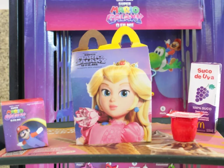 Caixa de McLanche Feliz com o rosto da Princesa Peach, acompanhada de suco de uva, maçã e uma pequena embalagem do Mario.