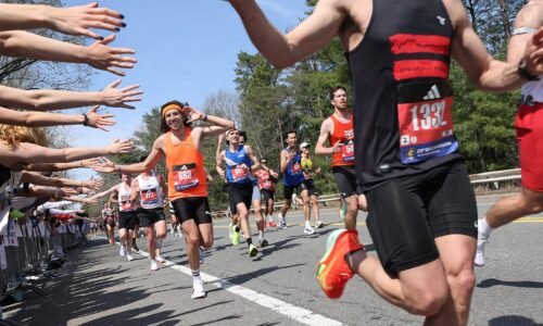 Runners react with joy when the Wellesley College students reach out to high-five as they pass during the Boston Marathon on April 21, 2025.