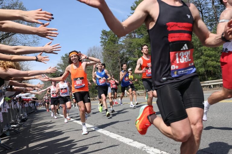 Runners react with joy when the Wellesley College students reach out to high-five as they pass during the Boston Marathon on April 21, 2025.