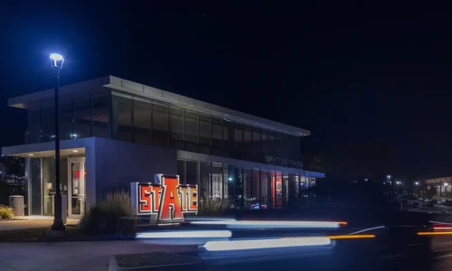 The A-State Welcome Center illuminated at night on campus.