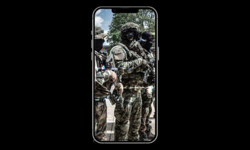 A photo of men in militia gear taken on a cell phone.