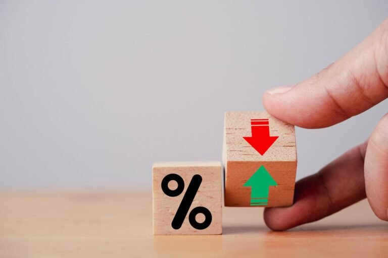 Beside a wooden block that shows a percent sign, a hand holds a second wood block that shows a green arrow point up and a red arrow pointing down.