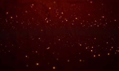 An extreme close-up photograph of a lush, velvety texture in deep shades of burgundy and gold, capturing the luxurious and glamorous essence of Ben Keaton