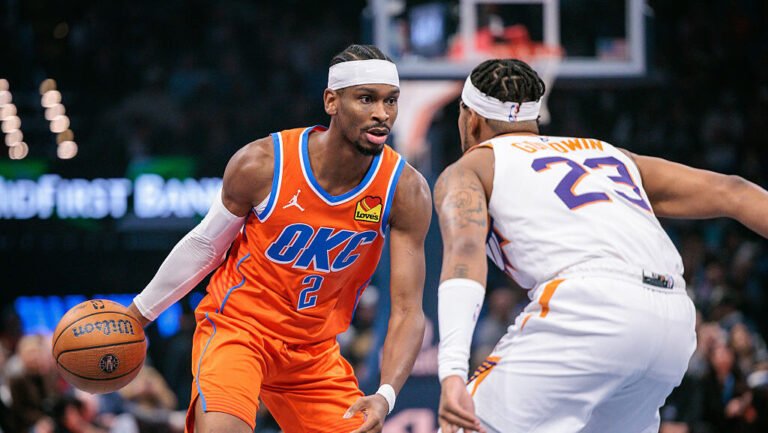 Shai Gilgeous-Alexander #2 of the Oklahoma City Thunder brings the ball up court around Jordan Good...