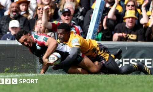 Gabriel Hamer-Webb in the act of getting over the line to score a try for Leicester Tigers despite being wrapped up in a tackle