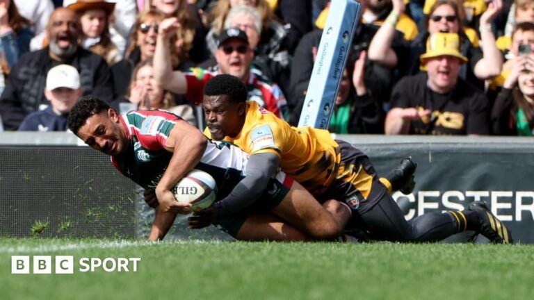 Gabriel Hamer-Webb in the act of getting over the line to score a try for Leicester Tigers despite being wrapped up in a tackle