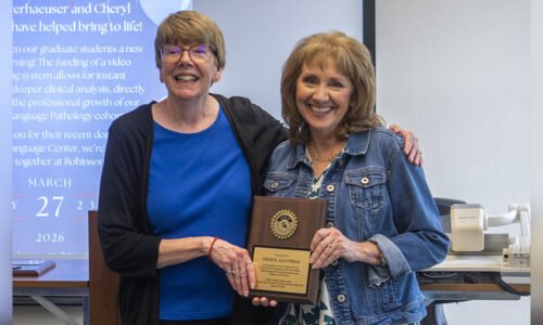 Dr. Brenda Heiman presents Cheryl Leachman with a plaque