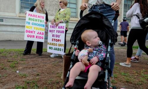Anti-vaccine protesters stage a protest outside of the San Diego Unified School District office to protest a forced vaccination mandate for students  on September 28, 2021 in San Diego, California. The School District was holding a virtual hearing on whether to enact a mandate for students to recieve at least one dose of a COVID vaccine. ((Photo by Sandy Huffaker/Getty Images))