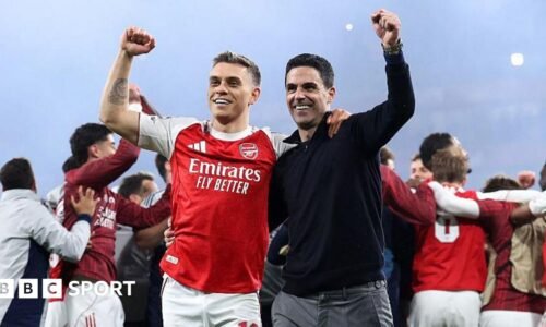 Leandro Trossard and Mikel Arteta celebrating on the Emirates Stadium pitch after beating Atletico Madrid.