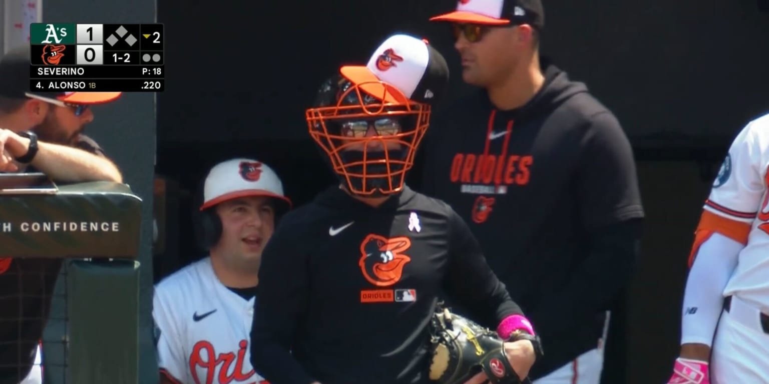 Craig Albernaz, Orioles manager, wears catcher's mask, glove in dugout