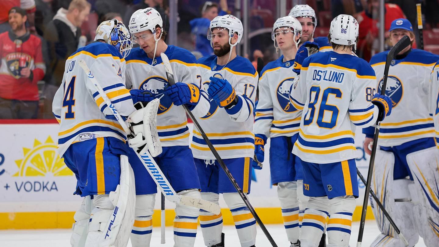 Buffalo Sabres players celebrate with goalie Alex Lyon