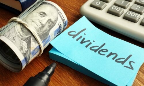 Rolled-up dollar bills with a post-it saying "dividends."
