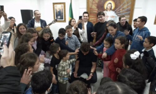 Nikolas Ferreira recebe oração de crianças em visita a instituição em Curitiba