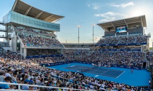 Tennis match being played on center court with the stands full
