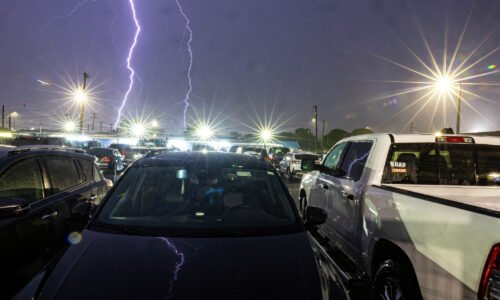 Lightning flashes over vehicles outside B&N Sports Bar in San Antonio as severe storms moved through the area during a tornado warning Tuesday night, May 26 2026.