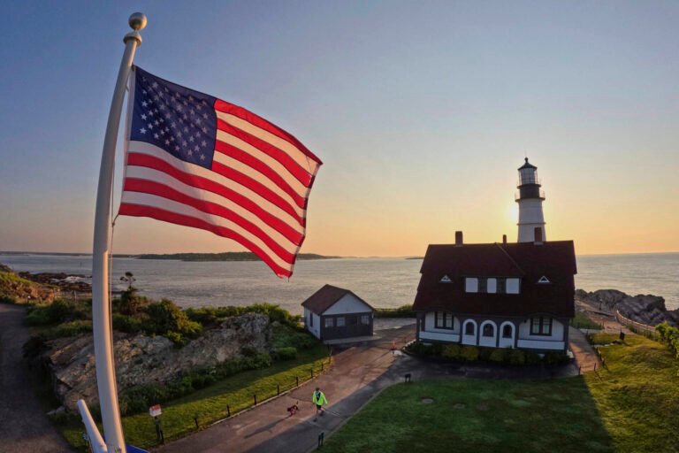 An American flag at Portland Head Light catches the light at sunrise, Wednesday, June 11, 2025, in Cape Elizabeth, Maine. (Robert F. BukatyAP)