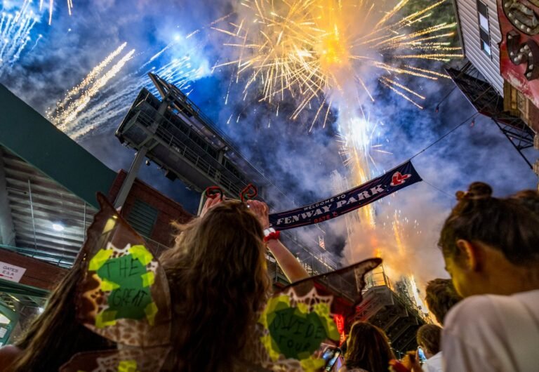 Camille Waddington takes a photo of fireworks from outside during a Noah Kahan concert inside Fenway Park in Boston, MA on July 11, 2026.