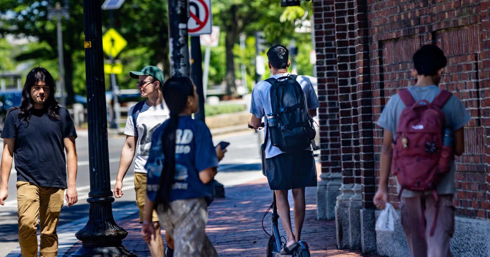 A teen rides an e-bike on Cross Street in Somerville. (Jesse Costa/WBUR)