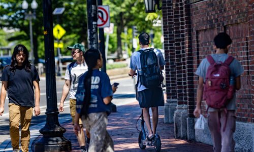 A teen rides an e-bike on Cross Street in Somerville. (Jesse Costa/WBUR)