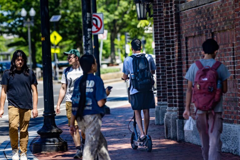 A teen rides an e-bike on Cross Street in Somerville. (Jesse Costa/WBUR)