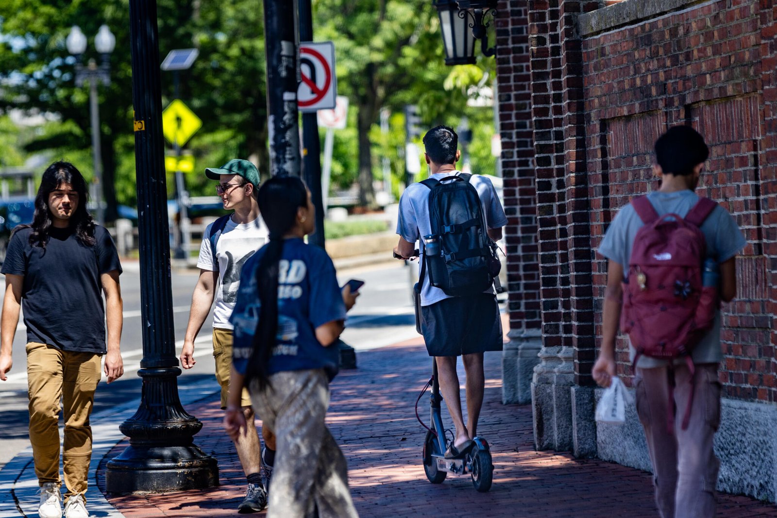 A teen rides an e-bike on Cross Street in Somerville. (Jesse Costa/WBUR)