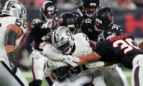 Las Vegas Raiders running back Mike Washington Jr., center, is stopped on a run against the Hou ...