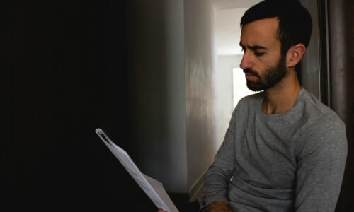 Trabalhador CLT conferindo o contracheque em casa, ilustrando o desconto em folha do consignado privado como alternativa ao rotativo do cartão