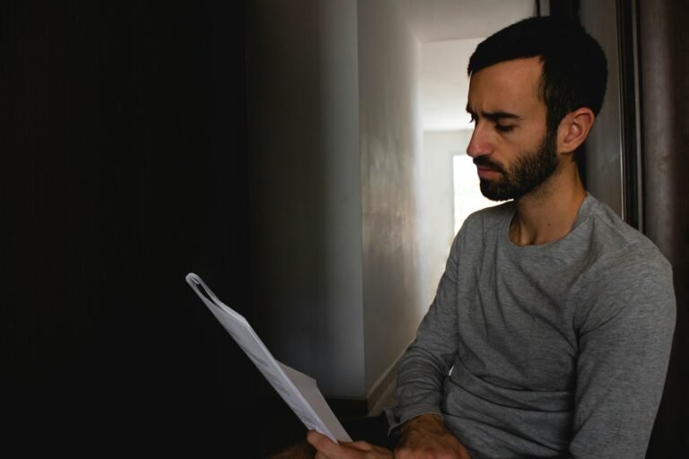 Trabalhador CLT conferindo o contracheque em casa, ilustrando o desconto em folha do consignado privado como alternativa ao rotativo do cartão