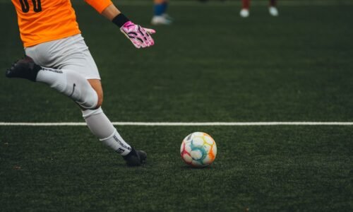 Goleiro se prepara para chutar a bola em um campo de futebol