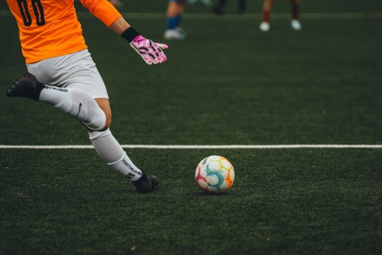 Goleiro se prepara para chutar a bola em um campo de futebol