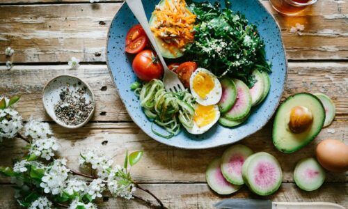 Mesa com variedade de alimentos frescos, verduras, frutas e ingredientes para uma alimentação saudável