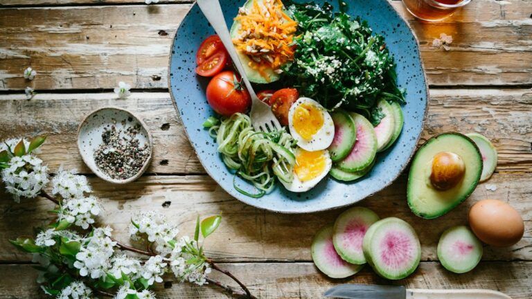 Mesa com variedade de alimentos frescos, verduras, frutas e ingredientes para uma alimentação saudável